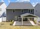 Backyard featuring a covered patio with white columns, lush green lawn, and mature trees at 168 Amber Acorn Ave, Raleigh, NC 27603