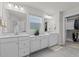Bathroom featuring dual vanities, white cabinets, and a view of the walk-in closet at 168 Amber Acorn Ave, Raleigh, NC 27603