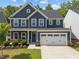 Charming two-story home featuring a two-car garage, landscaped yard, and inviting blue front door at 168 Amber Acorn Ave, Raleigh, NC 27603