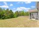 Wide, grassy backyard surrounded by trees, privacy fence, and screened porch at 170 Creekhaven Dr, Angier, NC 27501