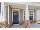 Inviting front porch with stone accents, sturdy white columns, and a stylish blue front door at 170 Creekhaven Dr, Angier, NC 27501