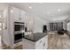 Modern kitchen with an island, stainless steel appliances, and white cabinetry opening up to the living room at 170 Creekhaven Dr, Angier, NC 27501