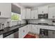 Modern kitchen with white cabinets, granite countertops, and stainless steel appliances at 170 Creekhaven Dr, Angier, NC 27501