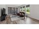 Bright living room with large windows, hardwood floors, and comfortable leather seating area at 170 Creekhaven Dr, Angier, NC 27501