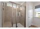 Tiled walk-in shower with glass door and window with natural light showcasing neutral color palette at 170 Creekhaven Dr, Angier, NC 27501