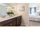 A bathroom with double sinks, white flower decor and a view into the bedroom at 171 Alice Trace Place, Angier, NC 27501