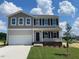 Charming two-story home with a well-maintained lawn and inviting curb appeal under a bright, cloudy sky at 171 Alice Trace Place, Angier, NC 27501