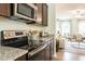 Kitchen featuring stainless steel appliances, granite countertops, and dark wood cabinetry at 171 Alice Trace Place, Angier, NC 27501