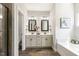 Bright bathroom with double vanity, soaking tub, tile floors, and modern fixtures at 1723 River Club Way, Franklinton, NC 27525