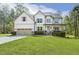 Charming two-story home featuring a covered porch, well-manicured lawn, and attached two-car garage at 1723 River Club Way, Franklinton, NC 27525