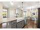 This spacious kitchen features a large granite island, farmhouse sink and stainless steel appliances at 1723 River Club Way, Franklinton, NC 27525