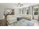 This living room boasts an oversized sofa, hardwood floors and is open to the kitchen with a ceiling fan at 1723 River Club Way, Franklinton, NC 27525