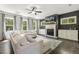 Cozy living room features dark hardwood floors, a ceiling fan, fireplace, and plenty of natural light at 1723 River Club Way, Franklinton, NC 27525