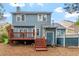 View of the back of the home with a wood deck and mature trees at 1725 Briarforest Pl, Raleigh, NC 27615