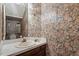 Half bath features a single sink vanity and floral wallpaper at 1725 Briarforest Pl, Raleigh, NC 27615