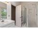 Bathroom features a glass door shower, single sink vanity and tiled floors at 1725 Briarforest Pl, Raleigh, NC 27615