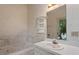 Bathroom features a tub, single sink vanity, and tiled walls at 1725 Briarforest Pl, Raleigh, NC 27615