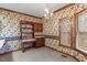 Cozy dining area with wallpaper, a chandelier, and a built-in desk and shelves by the window at 1725 Briarforest Pl, Raleigh, NC 27615