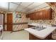 Kitchen with wallpaper, white countertops, stainless steel sink, and built-in cabinets at 1725 Briarforest Pl, Raleigh, NC 27615