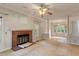 Open-concept living space featuring a brick fireplace, large window, and hardwood floors in the adjacent room at 1725 Briarforest Pl, Raleigh, NC 27615