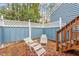 Cozy patio area with lounge chairs, enclosed by a privacy fence and featuring wooden stairs at 1725 Briarforest Pl, Raleigh, NC 27615