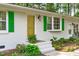Close up of the front entrance featuring white brick, green shutters, and a golden front door at 1805 Holly St, Apex, NC 27502