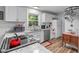Well-lit kitchen with white cabinets, granite counters, stainless steel appliances, and hardwood flooring at 1805 Holly St, Apex, NC 27502