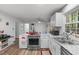 Charming kitchen featuring white cabinets, stainless steel appliances, and a view to the breakfast area at 1805 Holly St, Apex, NC 27502