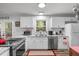 Well-lit kitchen featuring white cabinets, modern appliances, granite counters, and a window over the sink at 1805 Holly St, Apex, NC 27502