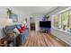 Living room with hardwood flooring, a blue sofa, and a bay window providing natural light at 1805 Holly St, Apex, NC 27502