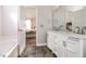Bathroom with white cabinets, double sinks and bathtub with views into the bedroom at 1808 Betry Pl, Raleigh, NC 27603