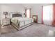 Comfortable bedroom with carpeted floors, grey bed frame, matching nightstands, and soft pink curtains at 1808 Betry Pl, Raleigh, NC 27603