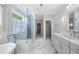 Bright bathroom featuring a soaking tub, glass enclosed shower and marble floors at 1820 Park Dr, Raleigh, NC 27605