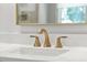 Close-up on gold bathroom fixtures on white countertops at 1820 Park Dr, Raleigh, NC 27605