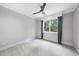 Bright bedroom featuring neutral walls, patterned carpet, ceiling fan, and ample natural light at 1820 Park Dr, Raleigh, NC 27605