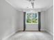 Bedroom with decorative window, neutral walls, patterned carpet, and ceiling fan at 1820 Park Dr, Raleigh, NC 27605
