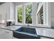 Modern kitchen sink with white cabinets and a large window overlooking a lush yard at 1820 Park Dr, Raleigh, NC 27605