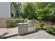 Backyard outdoor kitchen with built-in grill, stone surround, and lush greenery at 1820 Park Dr, Raleigh, NC 27605