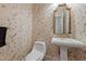 Charming powder room with floral wallpaper, a pedestal sink, and gold-framed mirror at 2037 Gurney Ct, Burlington, NC 27215