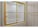 Bathroom shower-tub combo featuring white tile and gold framed glass doors with gold hardware at 2037 Gurney Ct, Burlington, NC 27215