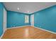 Bright bedroom with hardwood floors, blue walls, natural light from a window, and two white doors at 2037 Gurney Ct, Burlington, NC 27215