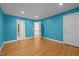 Bedroom featuring blue walls, hardwood floors, and white trim and doors with one door opened showing the hallway at 2037 Gurney Ct, Burlington, NC 27215