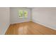 Bright bedroom featuring hardwood floors, white trim, and a window with outdoor views at 2037 Gurney Ct, Burlington, NC 27215