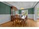 Elegant dining room with wooden table and chairs, built-in china cabinet, and green accent wall at 2037 Gurney Ct, Burlington, NC 27215