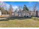 Daytime view of house featuring gray siding, white trim, manicured front lawn, and flag at 205 Coachman Dr, Garner, NC 27529