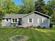 Charming home exterior featuring gray siding, white trim, landscaped yard, and an American flag at 205 Coachman Dr, Garner, NC 27529