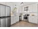 Modern kitchen featuring stainless steel appliances, white cabinets, and hardwood floors at 205 Coachman Dr, Garner, NC 27529