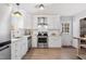 Updated kitchen with white cabinets, stainless steel appliances, and a view to the backyard at 205 Coachman Dr, Garner, NC 27529