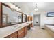A spacious bathroom featuring double sinks, tile floor, and a soaking tub visible in the mirror at 205 Olive Field Dr, Holly Springs, NC 27540