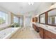 An expansive bathroom with a soaking tub, tiled shower, and double vanities at 205 Olive Field Dr, Holly Springs, NC 27540